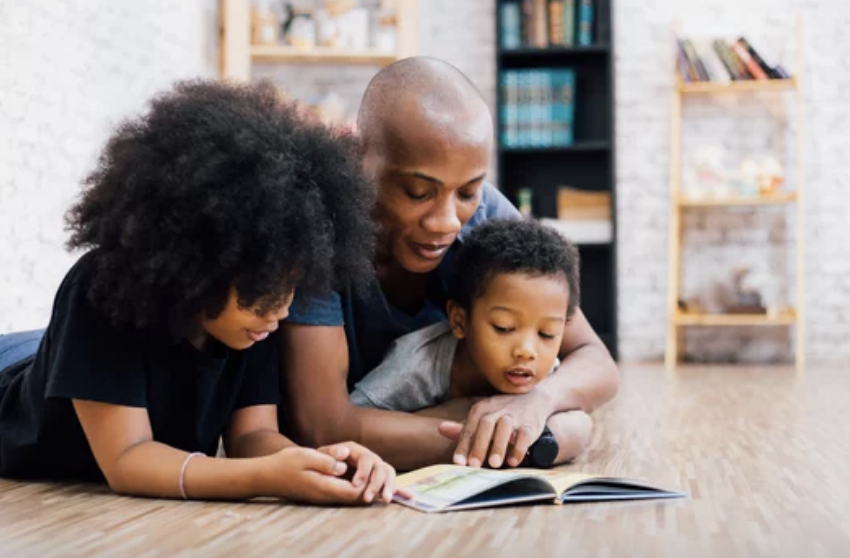 Mother and father reading book to young boy