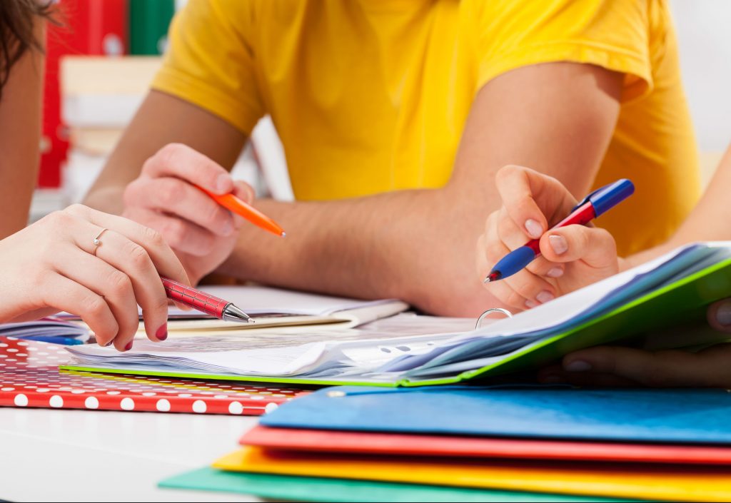 close up of kids hands doing homework in tutoring sessions.