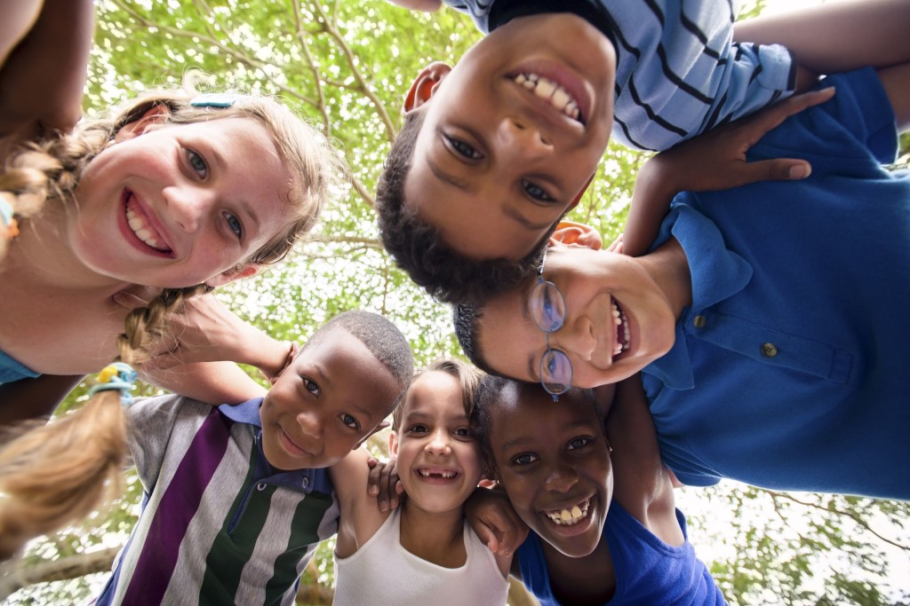 Children With Social Skills Deficits in a group circle smiling.