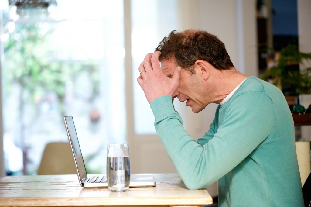 angry man stressed looking at his laptop.