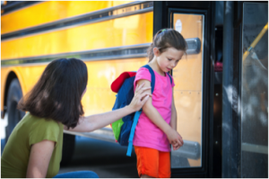 young girl dealing with separation anxiety getting on school bus