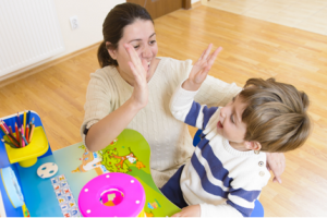 Psychologist and Little boy high five during Emotion Regulation session