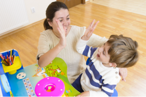 Psychologist and little boy high five