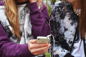 teen girls addicted to phone listening to music.