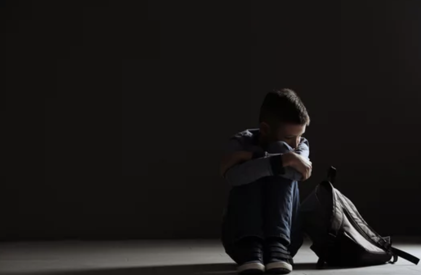 Child with Traumatic Stress sitting in dark room