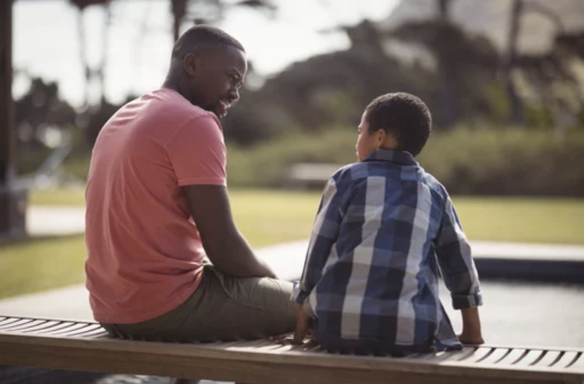 Father talking to son on park bench