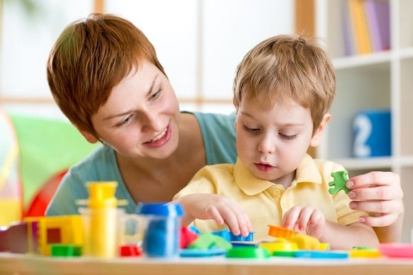 ABA therapist and child with autism playing with shapes in therapy session