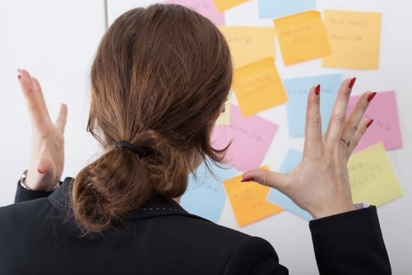 Woman stressed with post-its on board