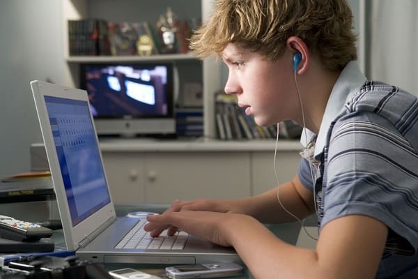 Teen on laptop looking at social media