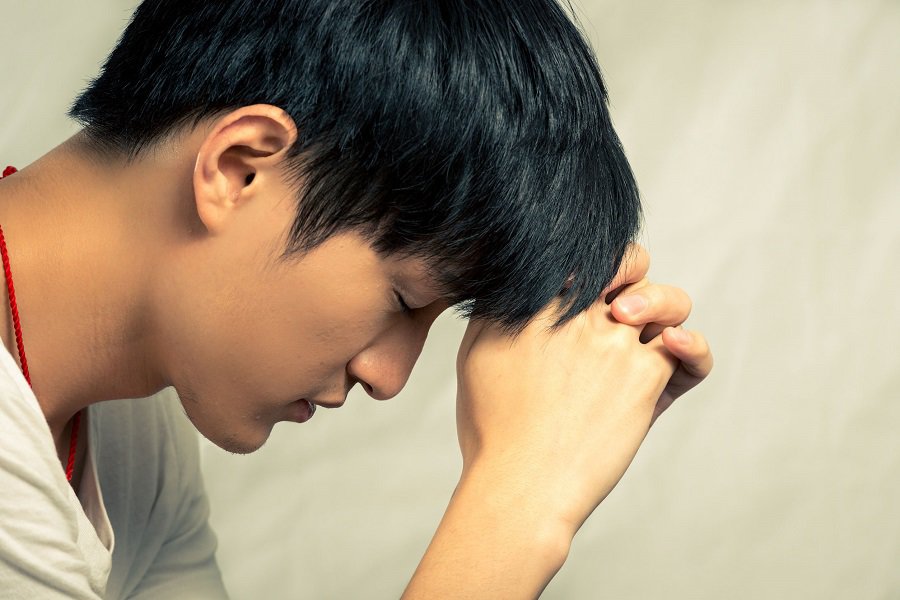 Stressed teen with head down.