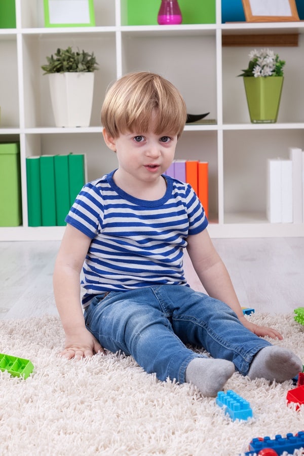 child sitting with toys in therapy session