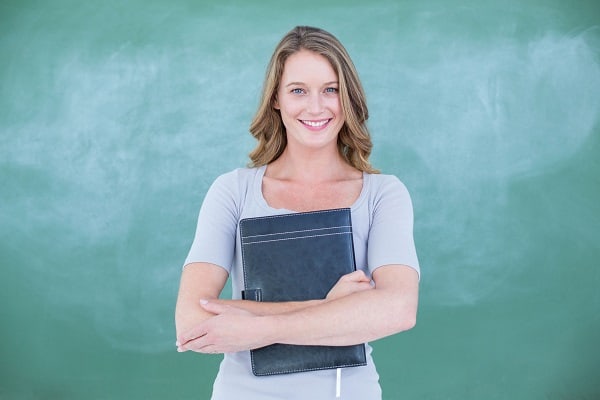 ABA therapist holding her booklet smiling