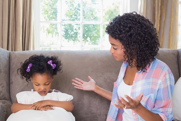 Mother scolding her daughter on the couch