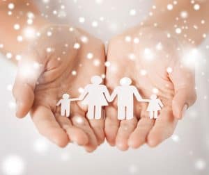 woman hands with paper cut out of a family holding hands