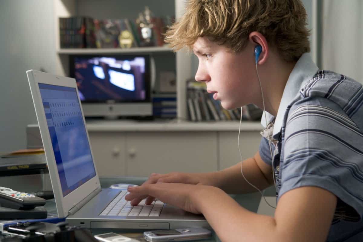 Teen on laptop listening to music