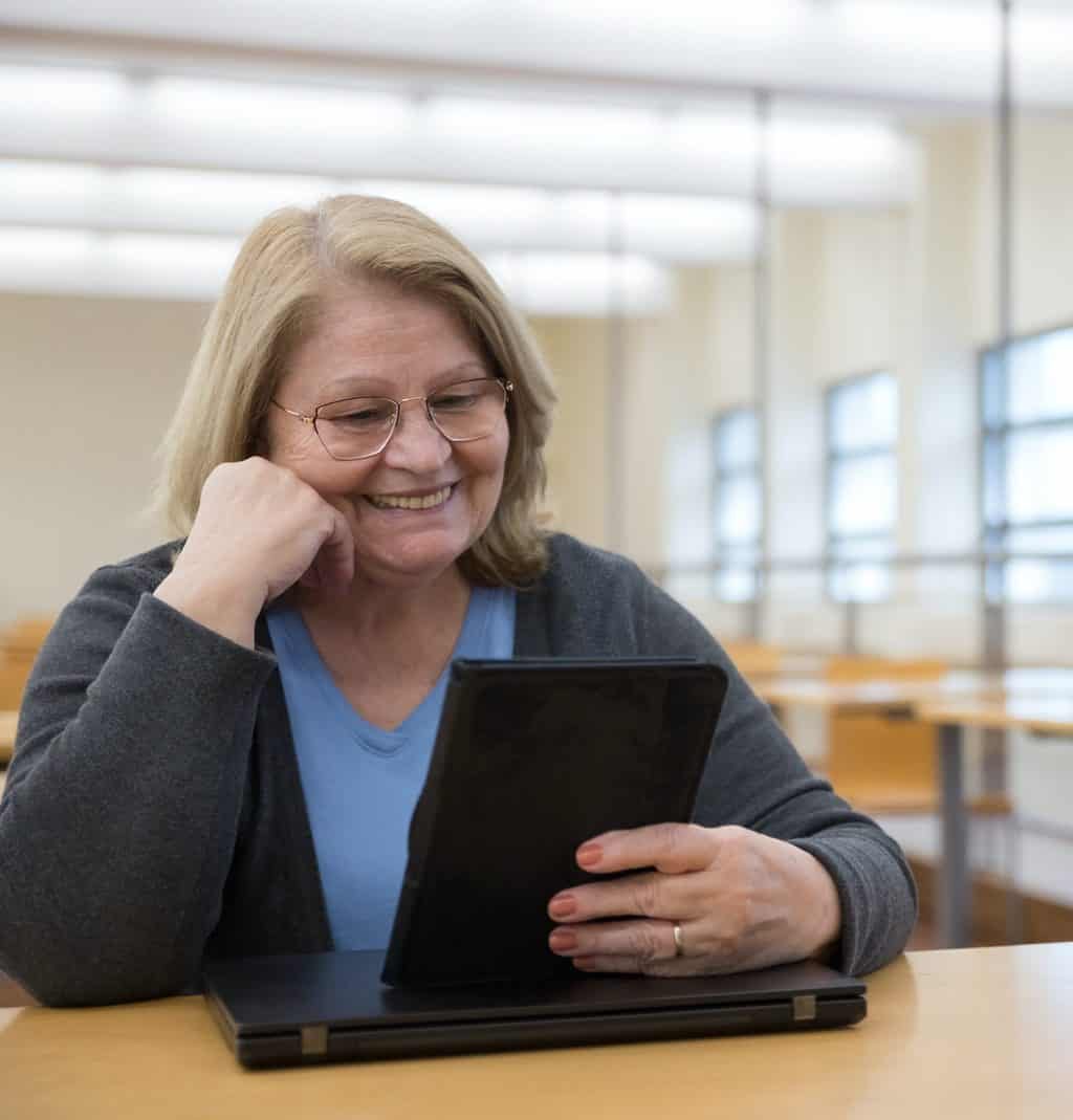 Older woman watching webinar on her tablet