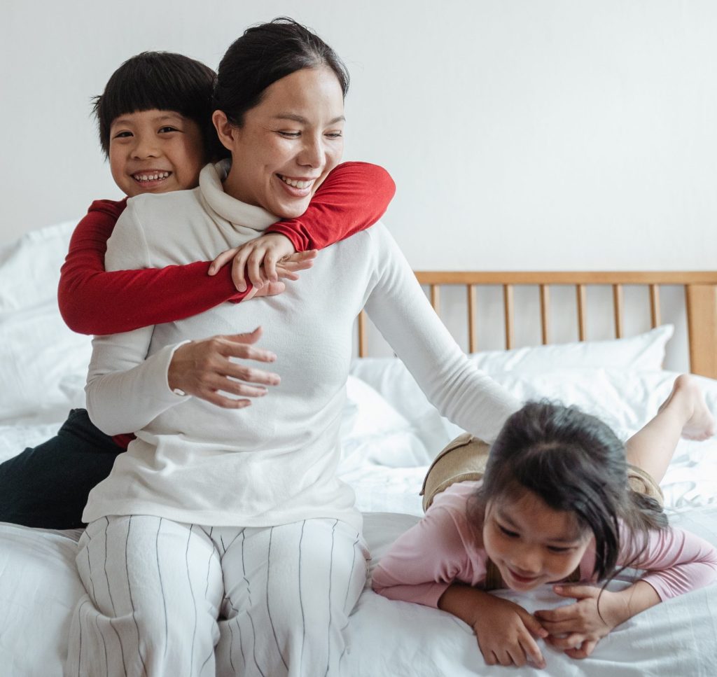 Mother with children on bed who have adhd.