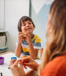 Kid smiling at psychologist in group session