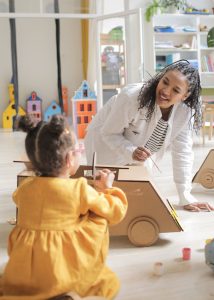 ABA therapist and little girl in session applying either DTT or NET ABA Therapy. 