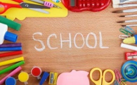 School Supplies with "School" written in chalk in middle of table