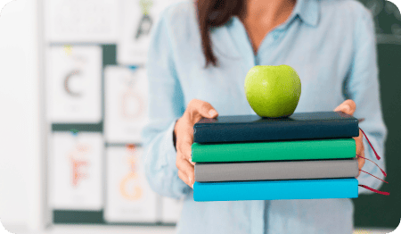 Tutor holding books with apple on top.