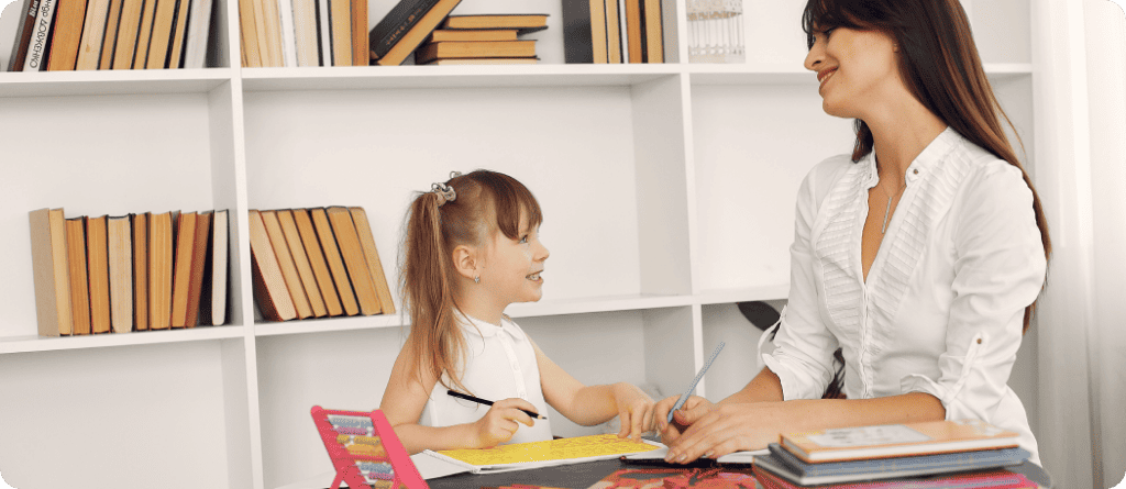 Psychologist smiling and little girl smiling at each other while doing activity.