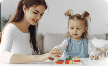 Psychologist helping little girl with a shape activity.