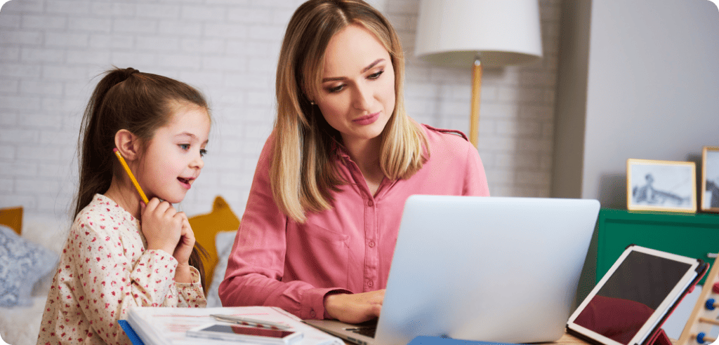 Tutor helping young child with homework on laptop.