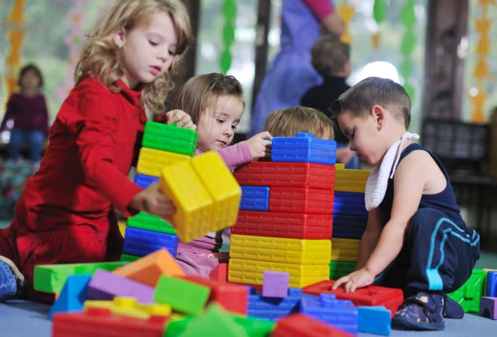 young kids playing with block tower.