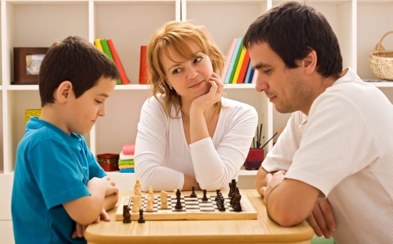 young boy playing chess with adult