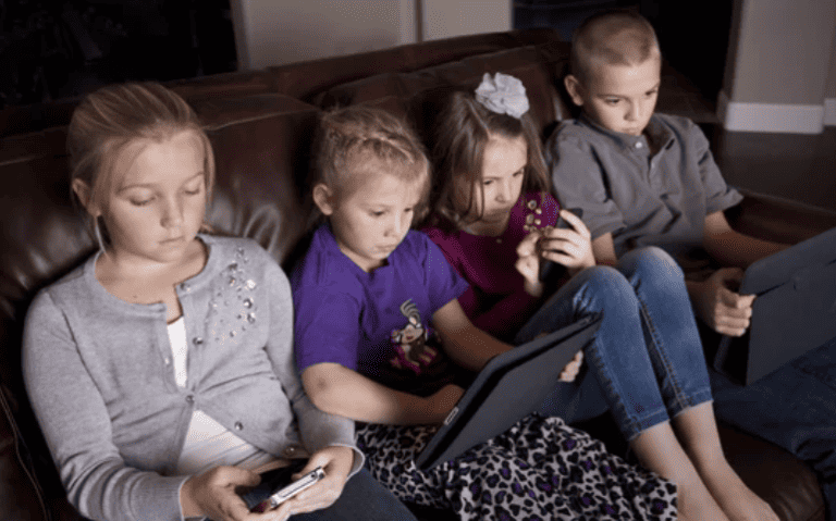 group of Children on couch Addicted to their Screens