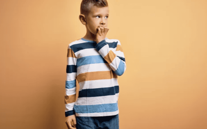 anxious child nail biting with orange background
