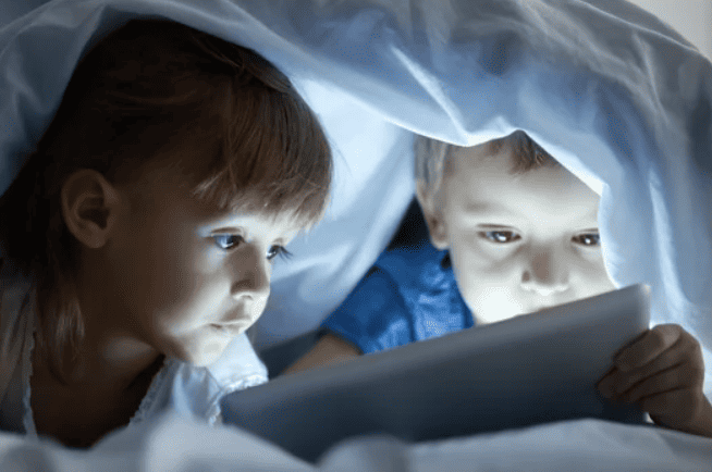kids under the cover on their tablets