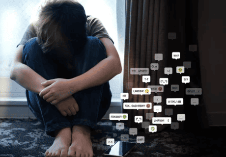 social media harassment concept. Young teenage boy sitting alone in the room feeling frustrated after reading bad comments. Text emoticons, online bullying