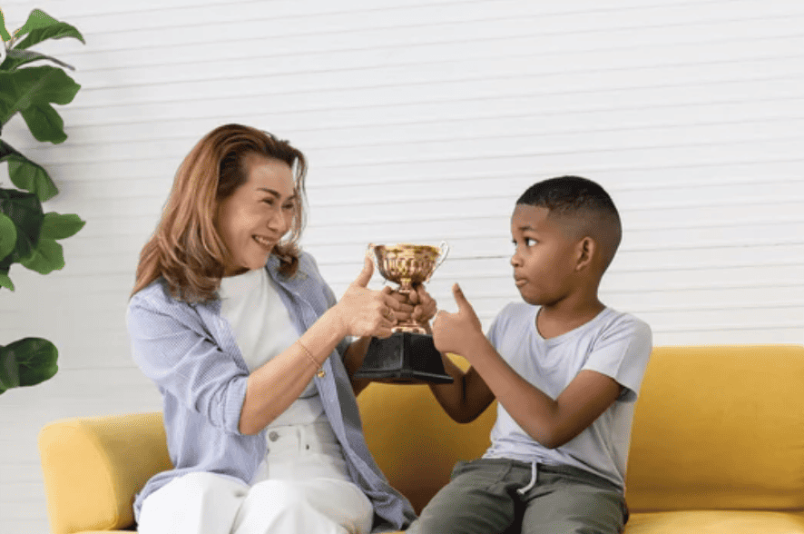 Parent giving kid praise Handing him award