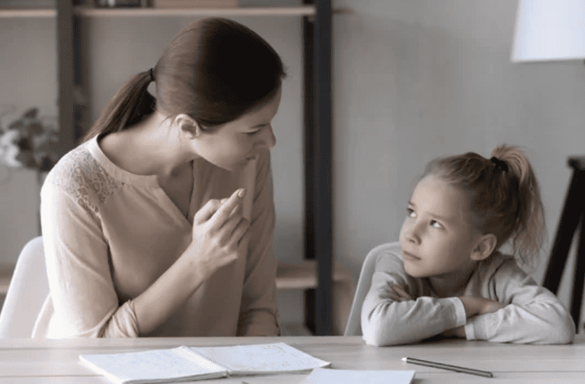 Parent disciplining child sitting on table with new parents styles method