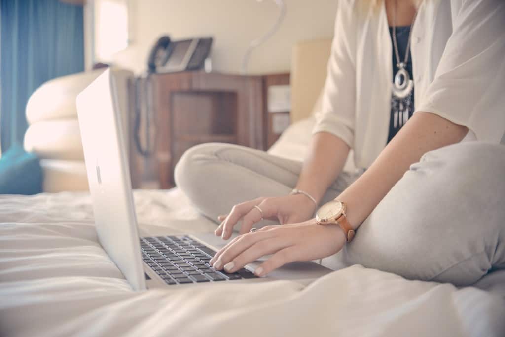 woman on bed on laptop Online Counseling
