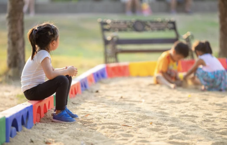 Child by herself not speaking to other children at school playground