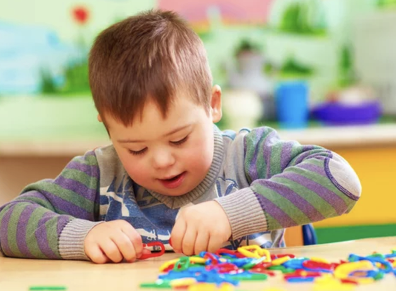 A Child with autism playing with colorful puzzle chain enjoying activity.