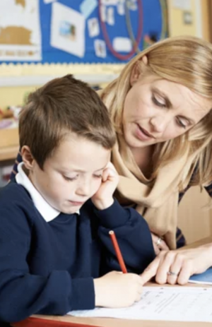 tutor helping kid with autism do school work.