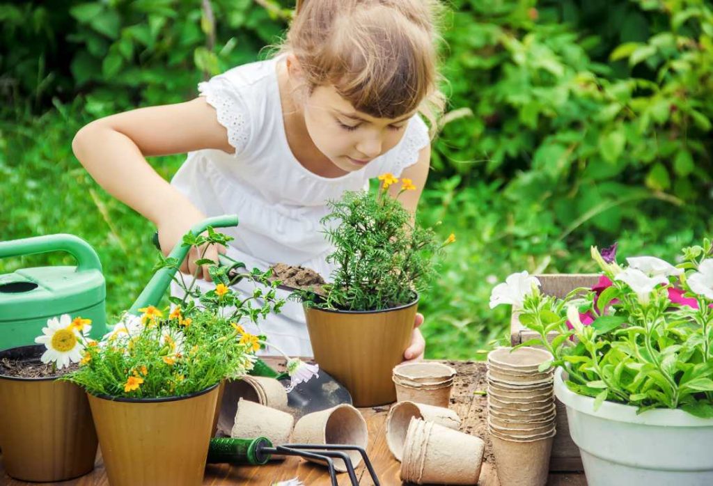 Girl helping at a garden. Random Acts of Kindness Challenge" encourages children to perform selfless deeds for others, whether it's helping a neighbor with their garden or assisting someone with their groceries