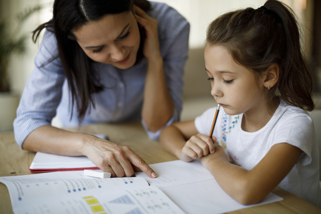 mother teaching daughter with dyslexia how to do homework.