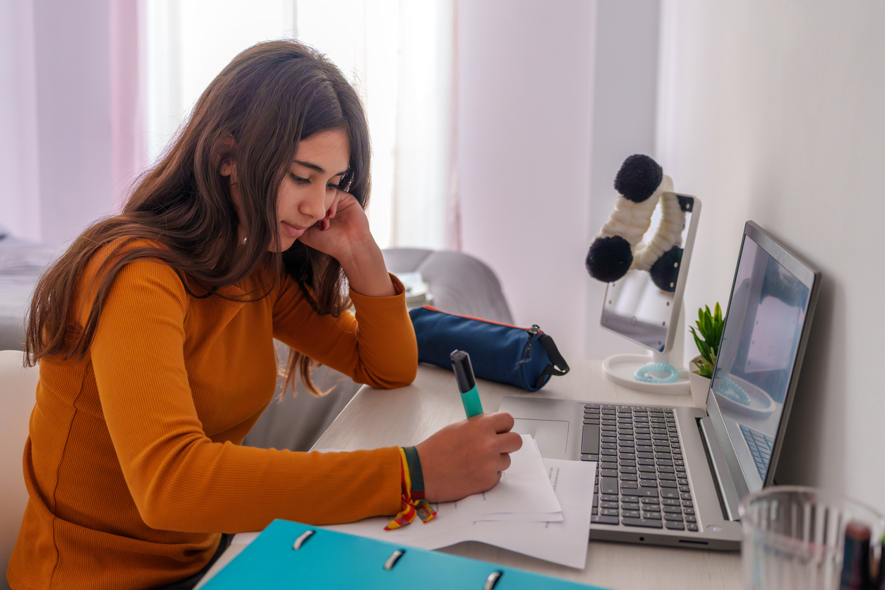 Teenage girl doing studying for midterms.